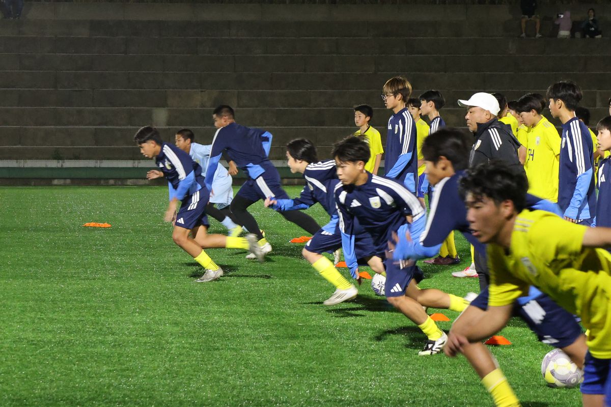 ナイター照明の下でダッシュする選手たち
