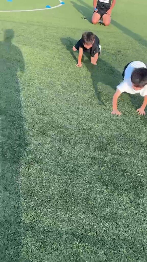 人工芝の上で、幼児クラスのお子さまが四つん這いで進んでいる様子